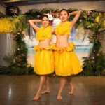 Two dancers dressed in yellow poses at the end of their performance.