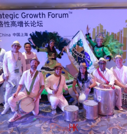 Percussion performers in white and dancers in green posing for photo