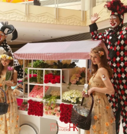 Stilts walkers standing next to flowers