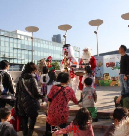 Three piece music trio on stage at Cyberport in Hong Kong wearing santa snowman and elf outfits
