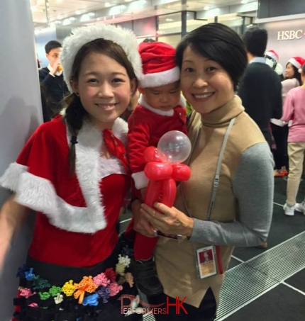 lady santa costume red with staff at hsbc private banking head quarters in hong kong central staff smiling with happiness and performer also smiling hong kong christmas