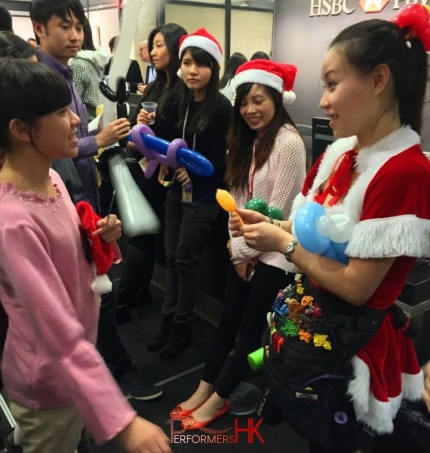 balloon twister cory in lady santa costume twisting balloons at hsbc hong kong head quarters central in red costume with staff very happily waiting for their christmas balloons Balloons Elf