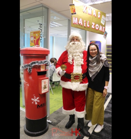 Santa standing next to a Xmas post box