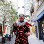 stilt walker juggling 5 balls whilst still walking in wan chai district hong kong