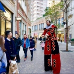stilt walker interacting with passer by in lee tung avenue