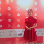 MC wearing red dress at event