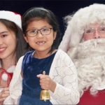 santa jay and santa girl with child holding bell