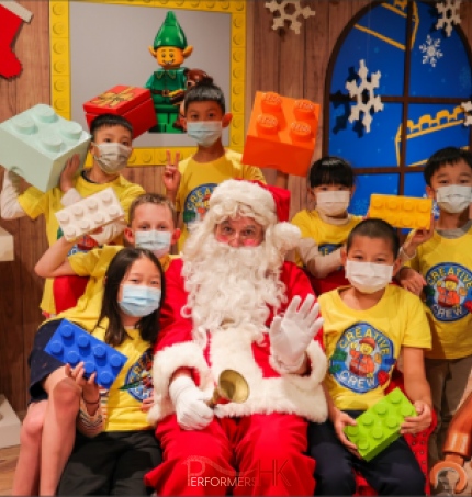 santa in red costme with children wearing yellow tops in tsim tsai tsui in Hong Kong