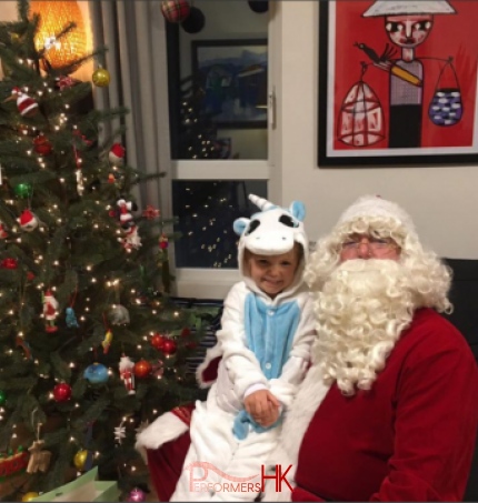 santa pete having a child sit on his lap during santa home visit