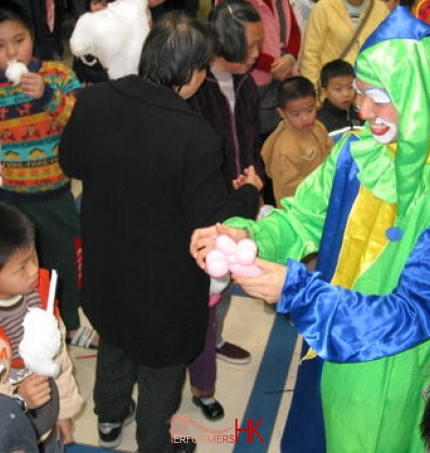 Hong Kong roving clown performer making a balloon for the little guest at a corporate family day event.
