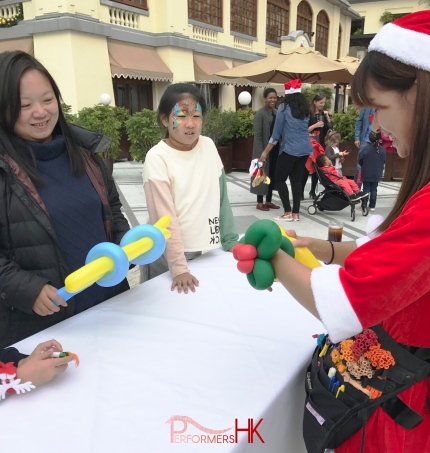 genie balloon twister in red lady santa costume at 109 repulse bay twisting balloons for patrons