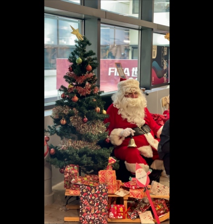 Santa sitting in front of a Christmas tree in Central market Hong kong