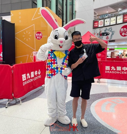 man with black t shirt stands next to easter bunny to take photos