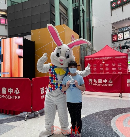 Easter bunny standing next to a girl taking photos, the girl is wearing blue top in hong kong shopping mall in sham shui po