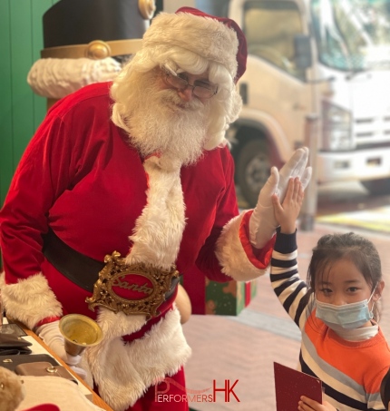 hong kong santa martin greeting litte girl high five in red costume