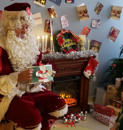 Santa Mario Chinese Santa reading stories to kids in front of a flase fire place in hong kong