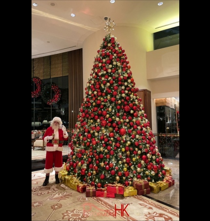 Santa Martin standing in front of a Giant Christmas Tree at Conrad Hotel in Hong Kong, a five star hotel, where he is performing Santa Clause in Hong Kong 2024 December
