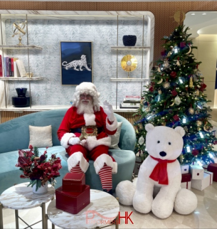 Santa Martin sitting on a light blue coach at the Cartier store in Central, Hong Kong for his Santa clause performance standing in front of a small christmas tree with a big bear next to him