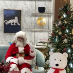 Santa Martin sitting on a couch in Cartier the luxury shop waving