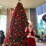 Santa Gerald at Conrad hotel, next to a giant Christmas Tree waving