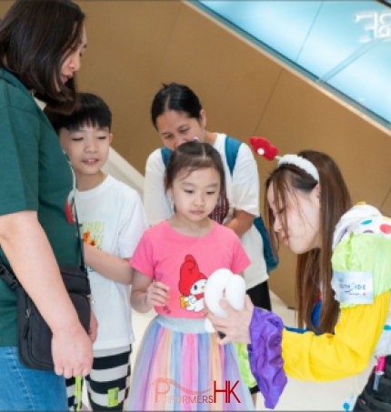 Cory making a baloon for a young shopper