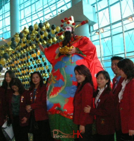 Stilt walker wearing giant inflatable Choi Sun costume at Hong Kong airport Chinese New Year event