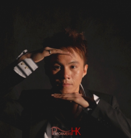 Hong Kong Magician head shot holding his hands in front of his forehead and chin 