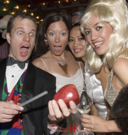 Walk around magician in Hong Kong performing roving magician with apple to a lady holing a glass of wine at a corporate cocktails event 