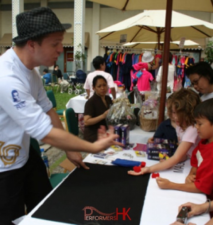 Hong Kong magician teaching two children sponge ball magic tricks at Hong Kong Repulse Bay