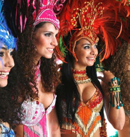 4 dancers in blue, pink, orange and green samba costumes